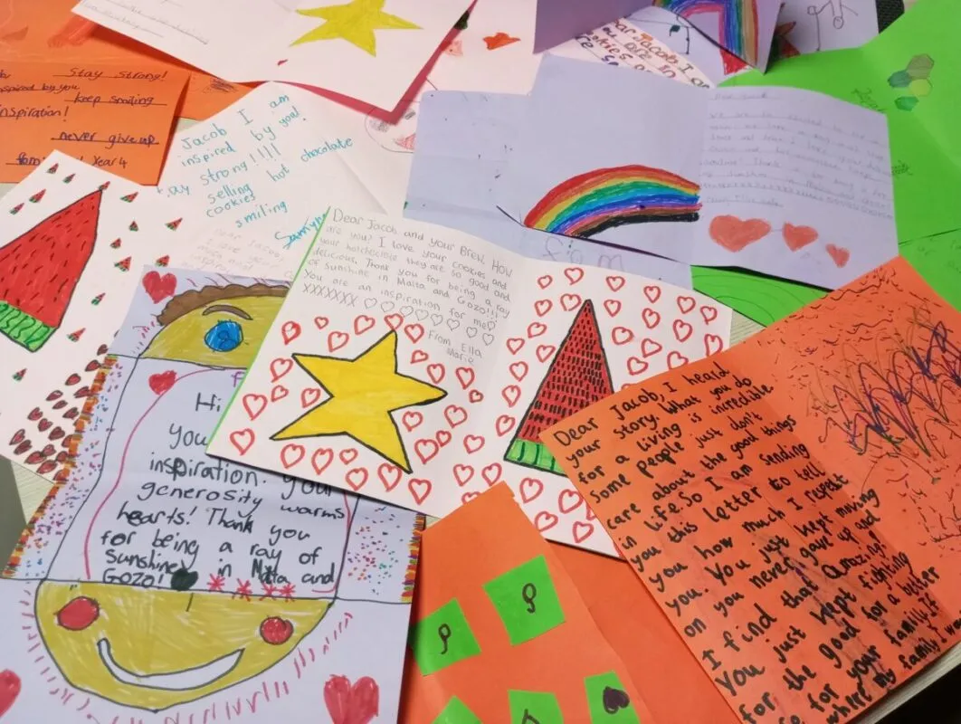 A tableful of hand-drawn cards and letters from schoolchildren, covered in hearts, stars and rainbows, thanking Jacob for inspiring them